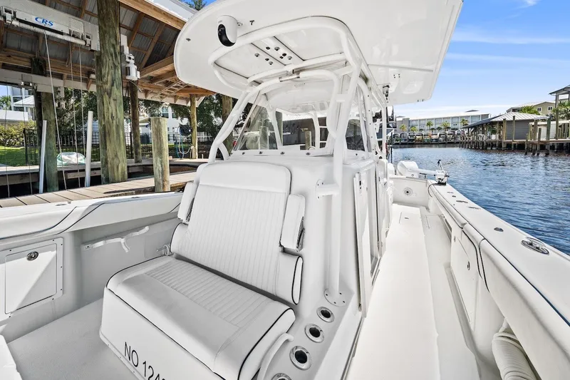 Slide: The Image of 2013 Yellowfin 39 Offshore boat interior with white seating, docked by a marina. - 30