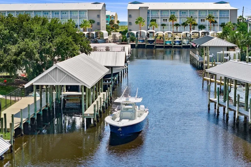 Slide: The Image of 2013 Yellowfin 39 Offshore boat docked in a scenic marina with waterfront buildings. - 7