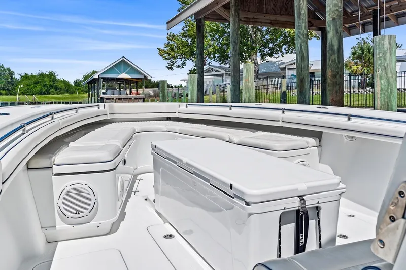 Slide: The Image of 2013 Yellowfin 39 Offshore boat interior with cushioned seating and storage under a dock. - 34