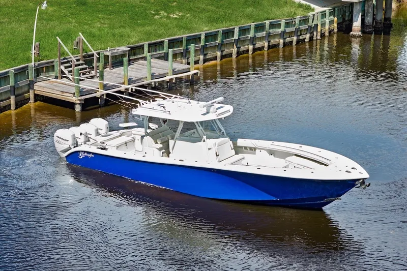 The Image of 2013 Yellowfin 39 Offshore boat with blue hull docked on calm water. - 0