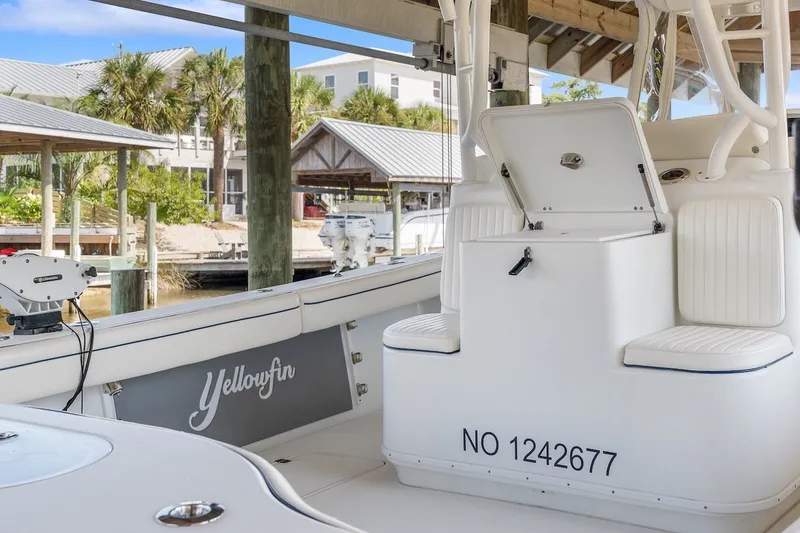 Slide: The Image of 2013 Yellowfin 39 Offshore boat interior with seating and storage, docked near palm trees. - 66
