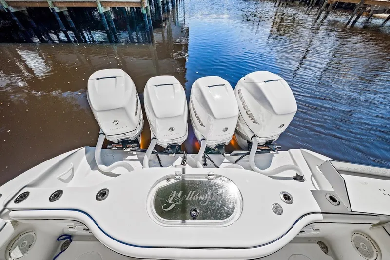 Slide: The Image of 2013 Yellowfin 39 Offshore boat with four Mercury outboard engines, docked by the water. - 41