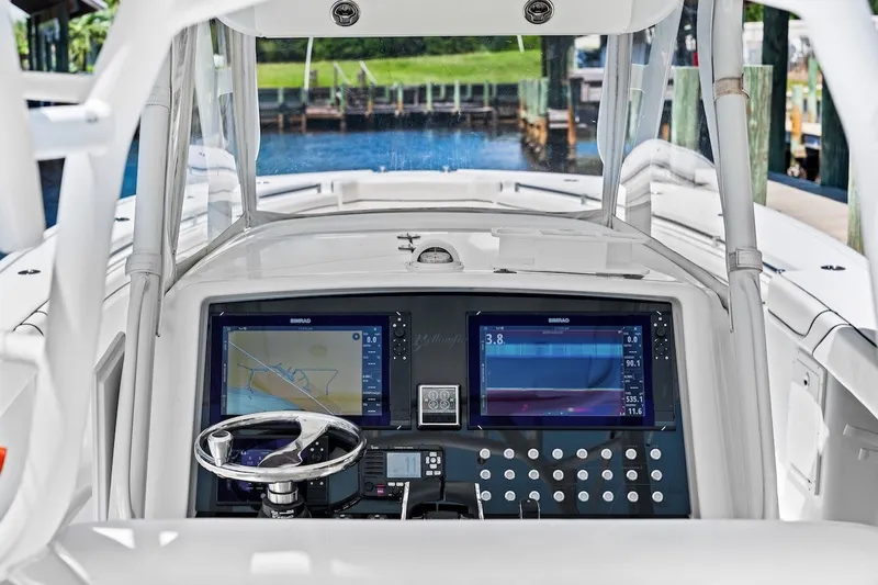 Slide: The Image of 2013 Yellowfin 39 Offshore boat dashboard with navigation screens and steering wheel. - 49