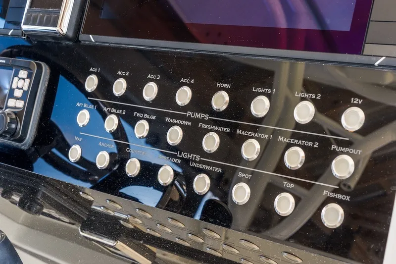 Slide: The Image of Control panel of a 2013 Yellowfin 39 Offshore boat with various switches and buttons. - 55