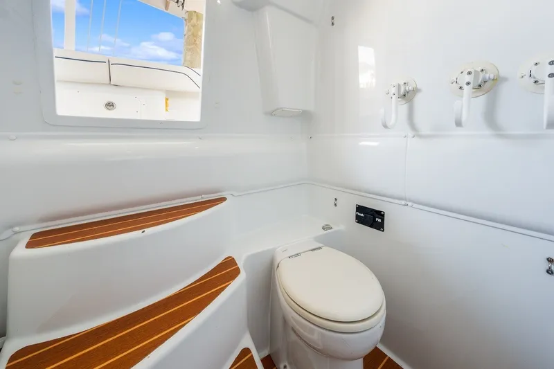 Slide: The Image of 2013 Yellowfin 39 Offshore boat bathroom with white interior and wooden accents. - 68