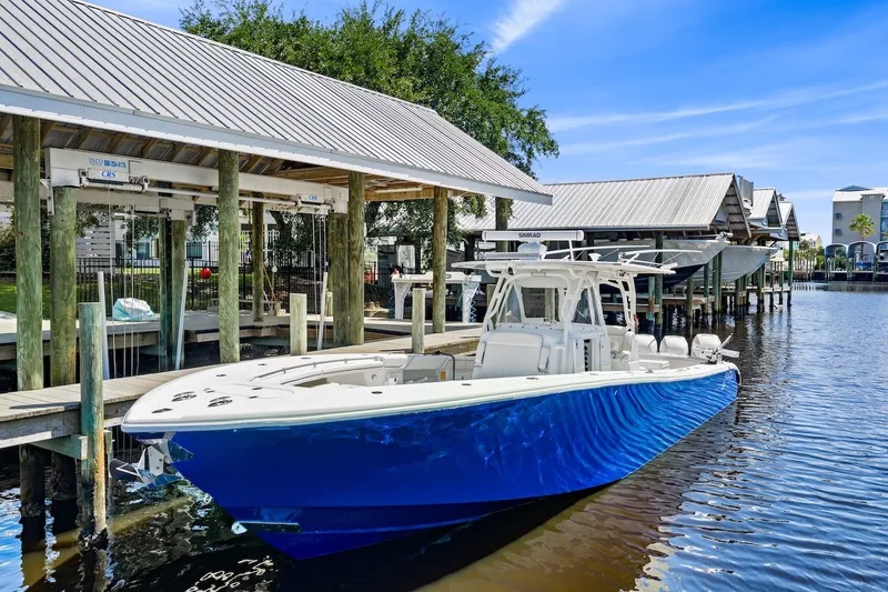 Slide: The Image of 2013 Yellowfin 39 Offshore boat docked, featuring sleek blue hull and modern design. - 16