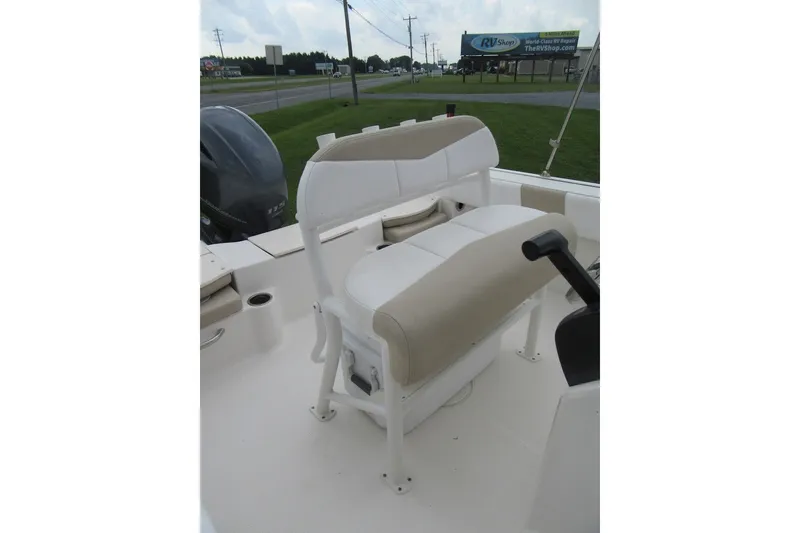 Slide: The Image of 2018 Robalo R180 Center Console boat interior with beige seating and steering controls. - 12