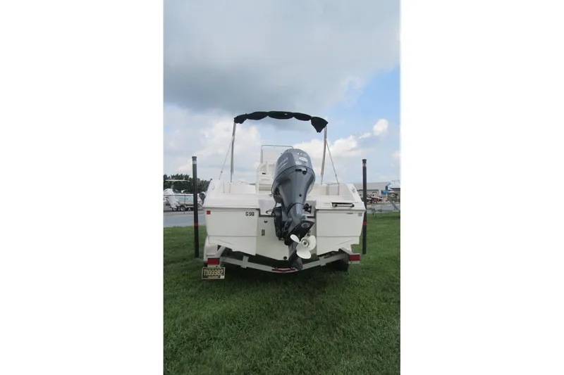 Slide: The Image of 2018 Robalo R180 Center Console boat on trailer, rear view, parked on grass. - 1