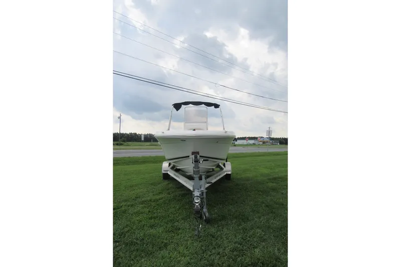 Slide: The Image of 2018 Robalo R180 Center Console boat on trailer, parked on grass under cloudy sky. - 3