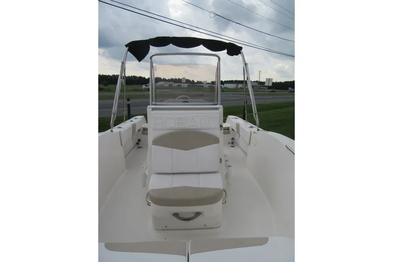 Slide: The Image of 2018 Robalo R180 Center Console boat with seating and canopy, parked outdoors. - 9
