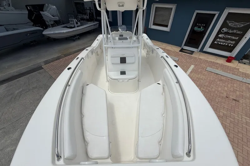 Slide: The Image of 2013 Tidewater 230 CC Adventure boat interior with white seating and console. - 18