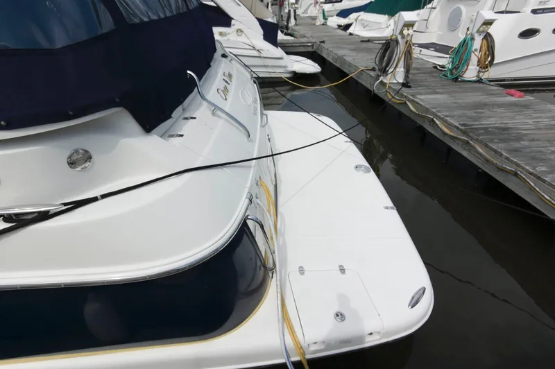 Slide: The Image of Ein Regal Commodore 3860 von 2005 liegt an einem Dock. Es hat ein weißes Deck und blaue Abdeckungen. - 1