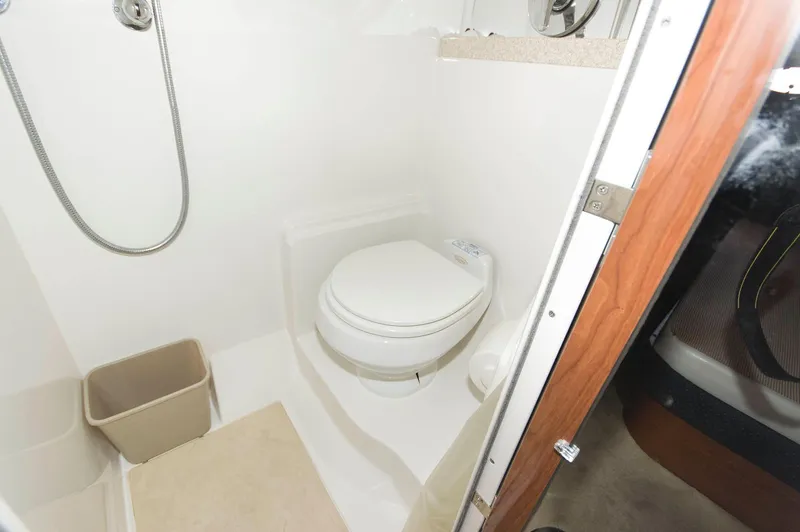 Slide: The Image of Das Bild zeigt ein Badezimmer auf einem Boot mit einer Toilette, einer Dusche und einem Mülleimer. - 17