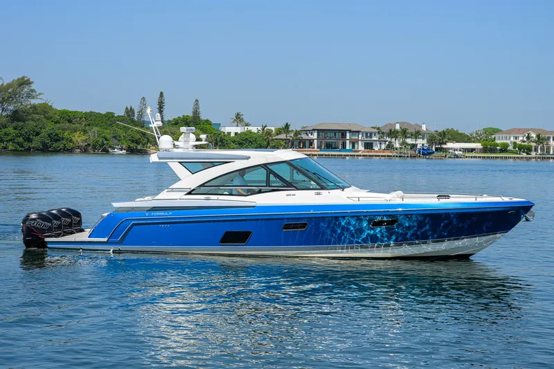 Slide: The Image of 2019 Formula 430 Super Sport Crossover yacht on calm water, with luxury homes in the background. - 53