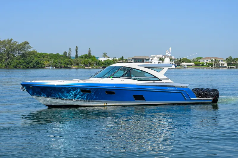 Slide: The Image of 2019 Formula 430 Super Sport Crossover boat on calm water, blue and white design. - 59