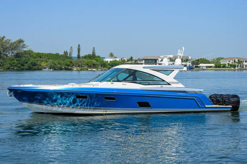 Slide: The Image of 2019 Formula 430 Super Sport Crossover boat on calm water, blue and white design. - 60