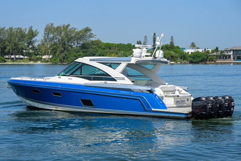 Slide: The Image of 2019 Formula 430 Super Sport Crossover boat on calm water, featuring sleek blue design. - 61