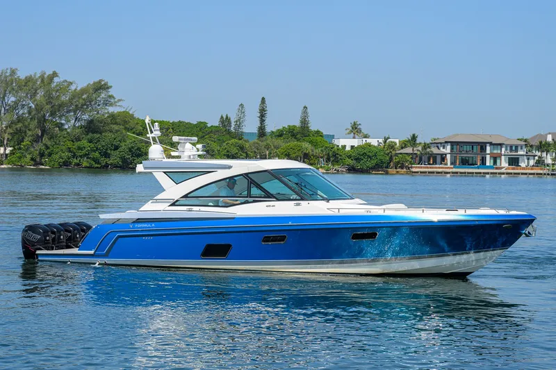 Slide: The Image of 2019 Formula 430 Super Sport Crossover boat on calm water, with a scenic background. - 54
