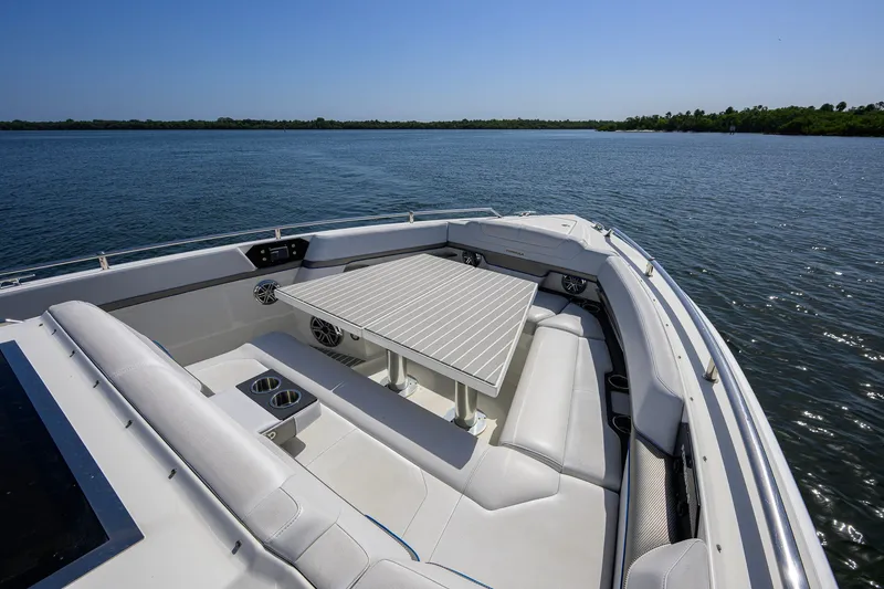 Slide: The Image of 2019 Formula 430 Super Sport Crossover boat interior with seating and table on calm water. - 51