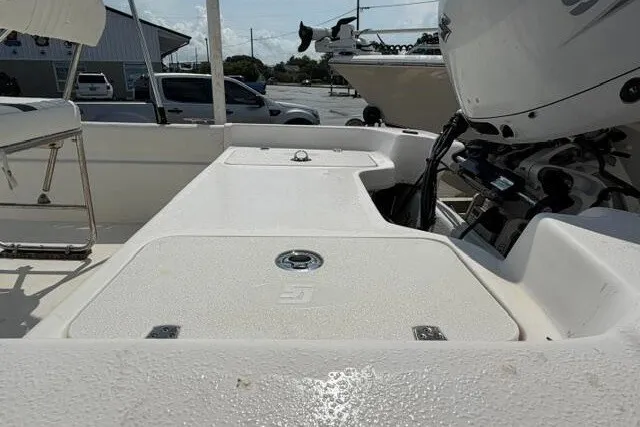 Slide: The Image of 2011 Carolina Skiff JVX18CC boat interior with motor, showing seating and storage. - 12