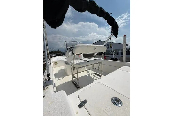 Slide: The Image of 2011 Carolina Skiff JVX18CC boat interior with seating and steering console under a cloudy sky. - 11