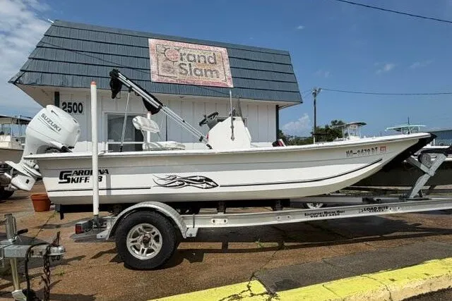 The Image of 2011 Carolina Skiff JVX18CC boat on trailer, parked outside a building. - 0