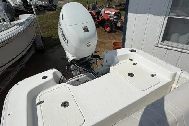 Slide: The Image of 2011 Carolina Skiff JVX18CC boat with Suzuki outboard motor, parked near a tractor. - 15