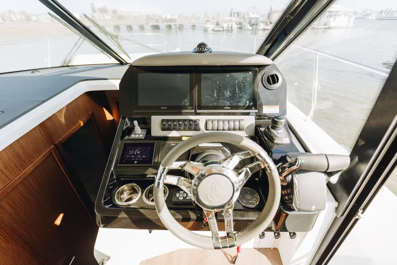 Slide: The Image of Helm of 2026 Beneteau Antares 12 Fly with modern navigation controls and steering wheel. - 14