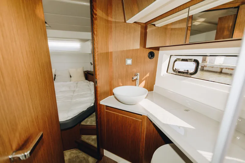 Slide: The Image of Luxurious interior of 2026 Beneteau Antares 12 Fly yacht, featuring modern bathroom and cozy bedroom. - 21