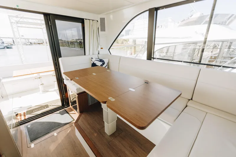 Slide: The Image of Interior of 2026 Beneteau Antares 12 Fly with elegant seating and wooden table. - 13