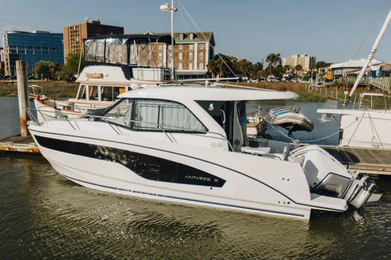 The Image of 2026 Beneteau Antares 9 docked in a marina, surrounded by other boats. - 0