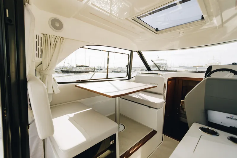 Slide: The Image of Interior of 2026 Beneteau Antares 9 yacht, featuring a cozy seating area and table. - 14