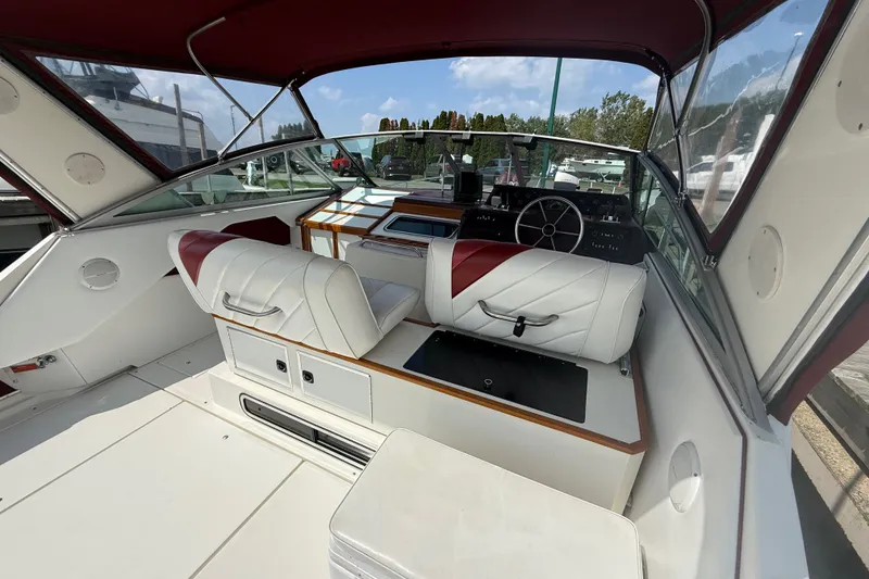 Slide: The Image of 1989 Sea Ray 340 Sundancer cockpit with white and red seating, steering wheel, and dashboard. - 10