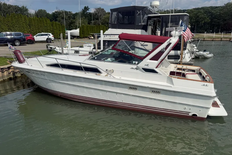 Slide: The Image of 1989 Sea Ray 340 Sundancer docked at marina with American flag. - 4