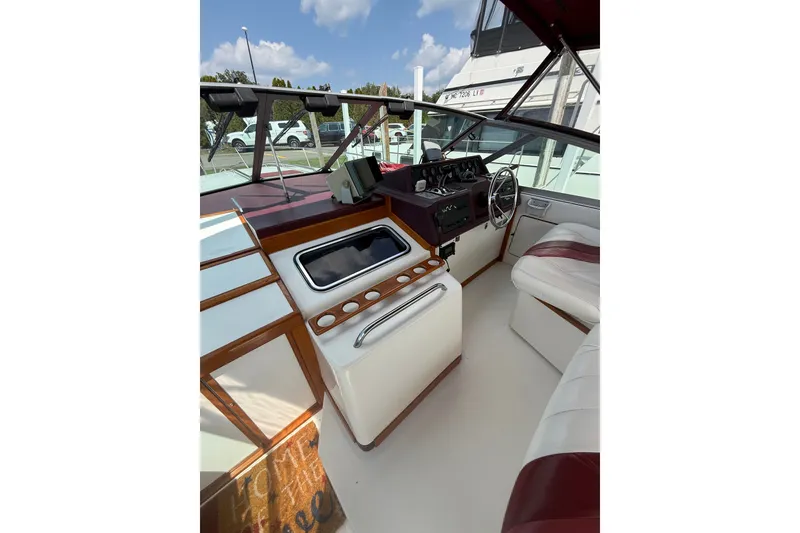 Slide: The Image of 1989 Sea Ray 340 Sundancer cockpit with steering wheel, dashboard, and seating under blue sky. - 15