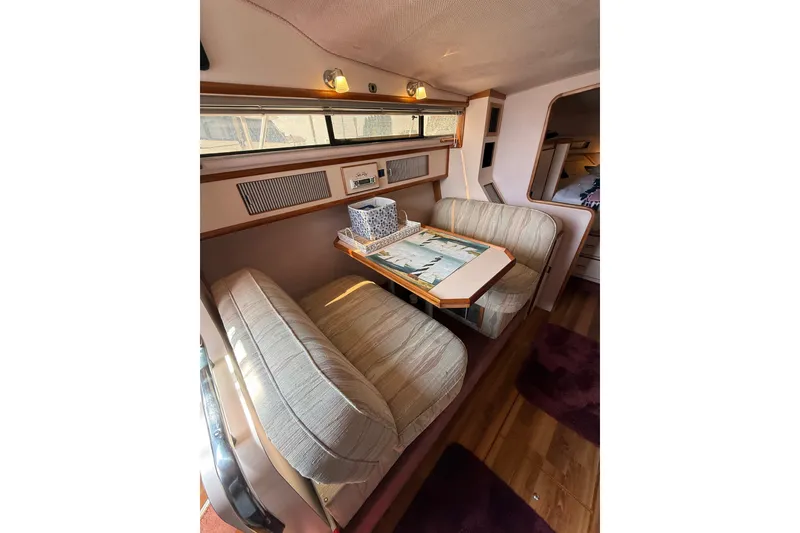 Slide: The Image of Interior of 1989 Sea Ray 340 Sundancer with cozy seating and dining area. - 21