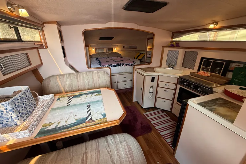 Slide: The Image of Interior of 1989 Sea Ray 340 Sundancer with cozy dining and kitchen area. - 19