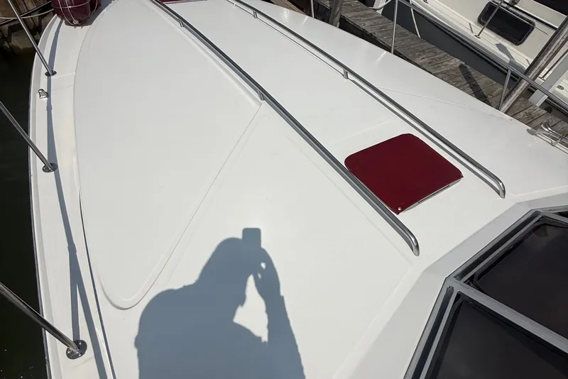 Slide: The Image of 1989 Sea Ray 340 Sundancer boat deck with railing and hatch, docked at marina. - 7