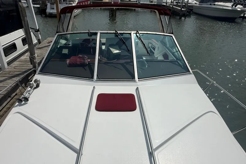 Slide: The Image of 1989 Sea Ray 340 Sundancer docked at marina, featuring sleek white deck and windshield. - 8