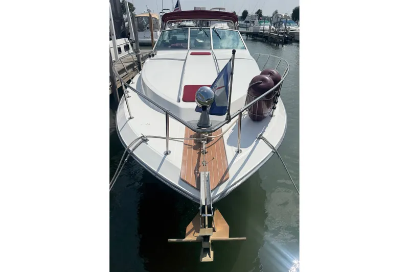 Slide: The Image of 1989 Sea Ray 340 Sundancer docked at marina, front view with flag and fenders. - 6