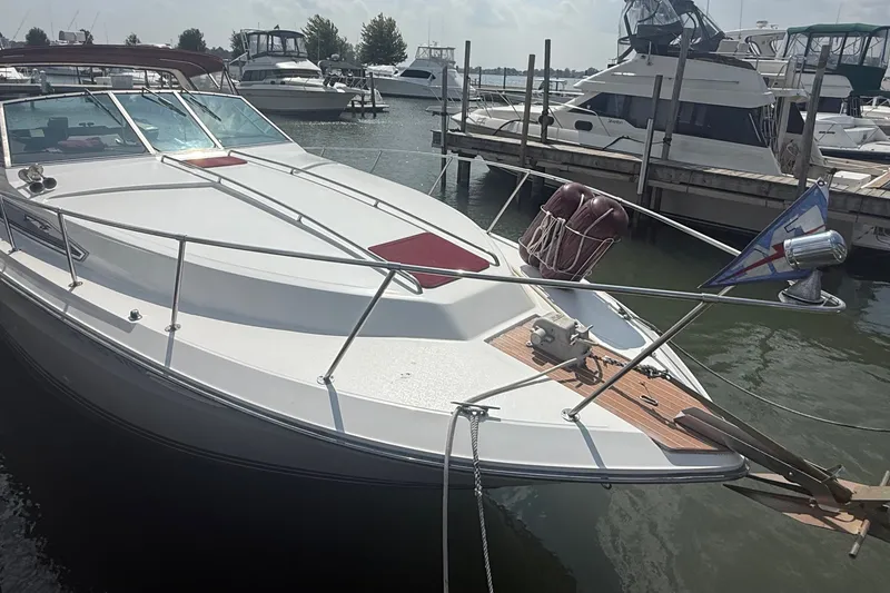 Slide: The Image of 1989 Sea Ray 340 Sundancer docked at marina, featuring sleek design and spacious deck. - 5
