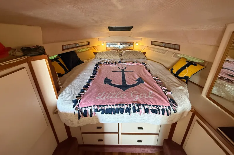 Slide: The Image of Cozy cabin interior of 1989 Sea Ray 340 Sundancer with nautical-themed bedding. - 23