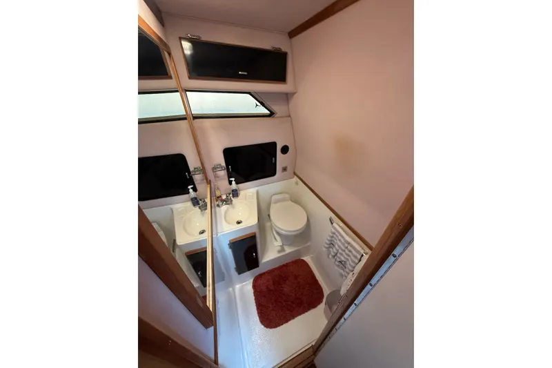 Slide: The Image of Bathroom interior of 1989 Sea Ray 340 Sundancer yacht, featuring sink and toilet. - 29