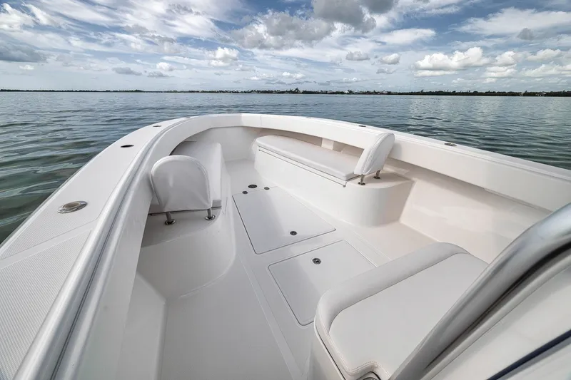 Slide: The Image of 2016 Bahama 41 boat interior with white seating, open water, and cloudy sky. - 28