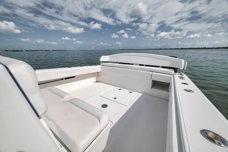 Slide: The Image of 2016 Bahama 41 boat interior with white seating, on calm water under a cloudy sky. - 19