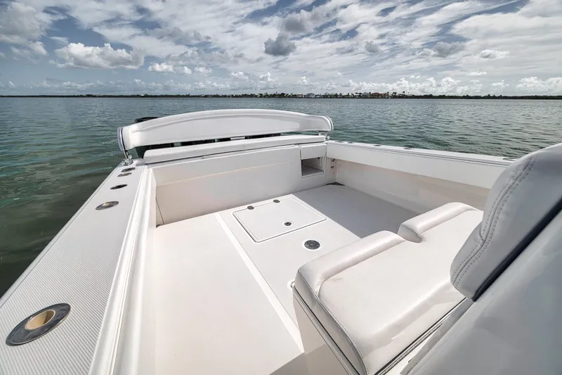 Slide: The Image of 2016 Bahama 41 boat interior with white seating, open water view, and cloudy sky. - 17
