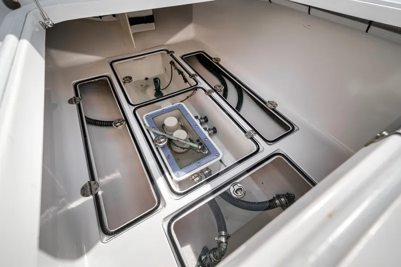 Slide: The Image of Bilge compartment of a 2016 Bahama 41 boat, featuring multiple access hatches and hoses. - 22