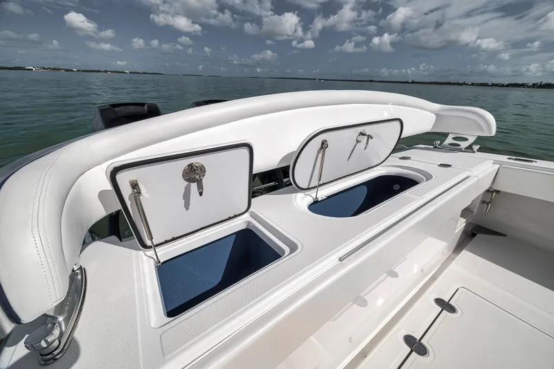 Slide: The Image of 2016 Bahama 41 boat with open storage compartments on deck, under a cloudy sky. - 20