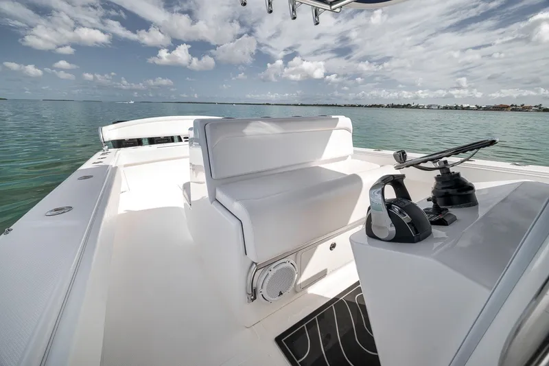 Slide: The Image of 2016 Bahama 41 boat interior with steering console, white seating, and ocean view. - 11