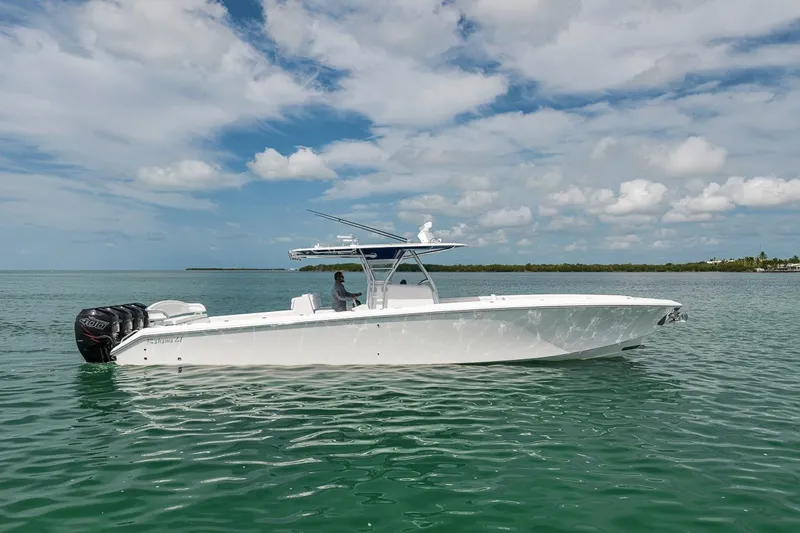 Slide: The Image of 2016 Bahama 41 boat cruising on calm waters under a partly cloudy sky. - 1